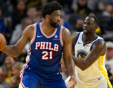 Philadelphia 76ers center Joel Embiid (21) looks to pass around Golden State Warriors forward Draymond Green (23) during the second half of an NBA basketball game, Tuesday, Jan. 30, 2024, in San Francisco.