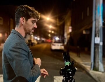 Brendan Happe of Philly Moon Men with his telescope on South Street.