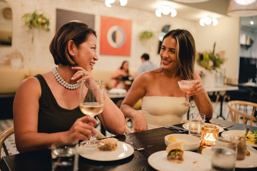 Two people smile as they talk over dinner at a restaurant