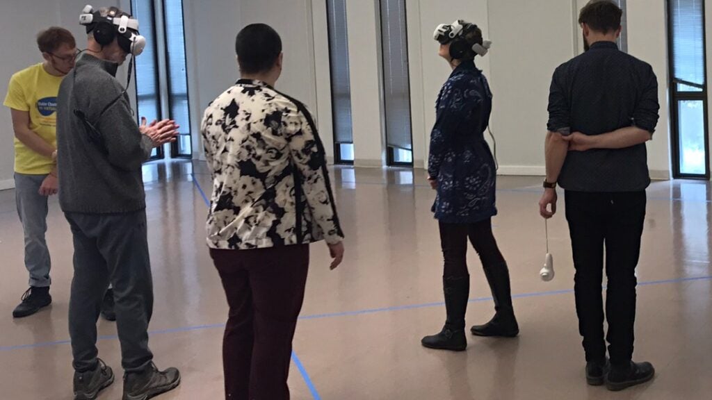 Audio Engineer Henrik Oppermann adjusts VR headset for reporter Grant Hill.