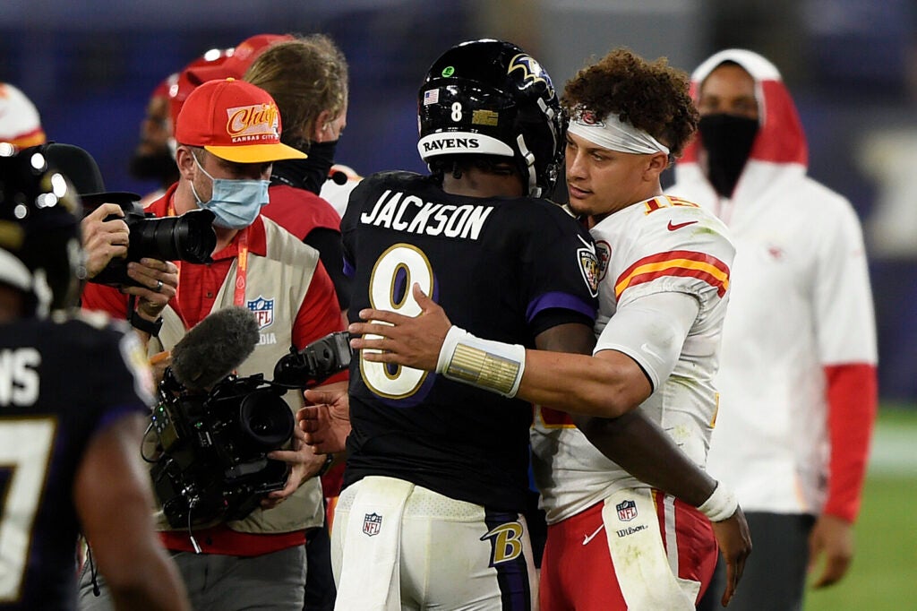 Baltimore Ravens quarterback Lamar Jackson, center, and Kansas City Chiefs quarterback Patrick Mahomes, right, embrace after an NFL football game in 2020, in Baltimore. Jackson and Mahomes will face each other in the AFC championship game in Baltimore on Sunday.