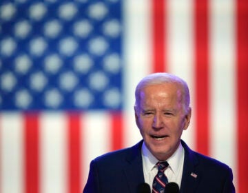 President Joe Biden speaks in front of a U.S. flag