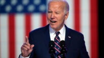 Biden speaking in front of the backdrop of a U.S. flag