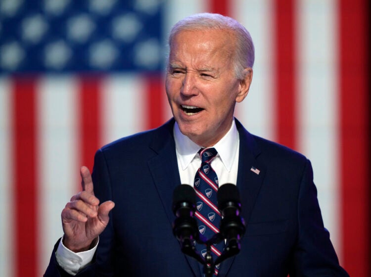 Biden speaking in front of the backdrop of a U.S. flag