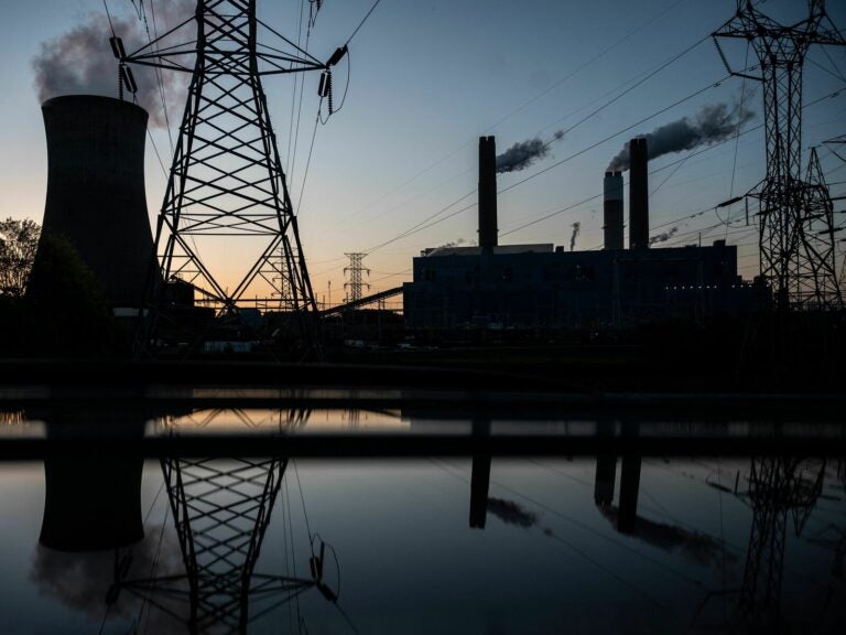 A coal-fired facility silhouetted against the setting sun