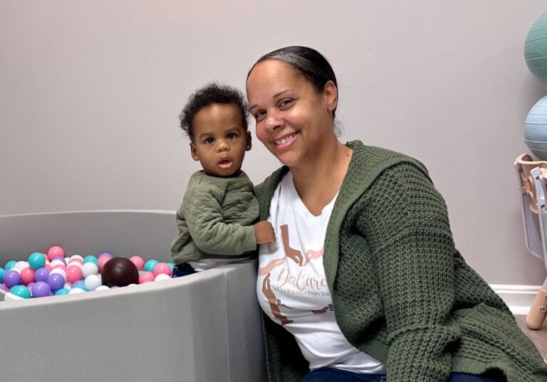 Erica Allen, Executive Director of the Do Care Doula Foundation, engaging with her son in the children's play area. (Johnny Perez-Gonzalez/WHYY)