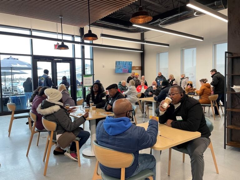 People sit at tables in a cafe, drinking coffee