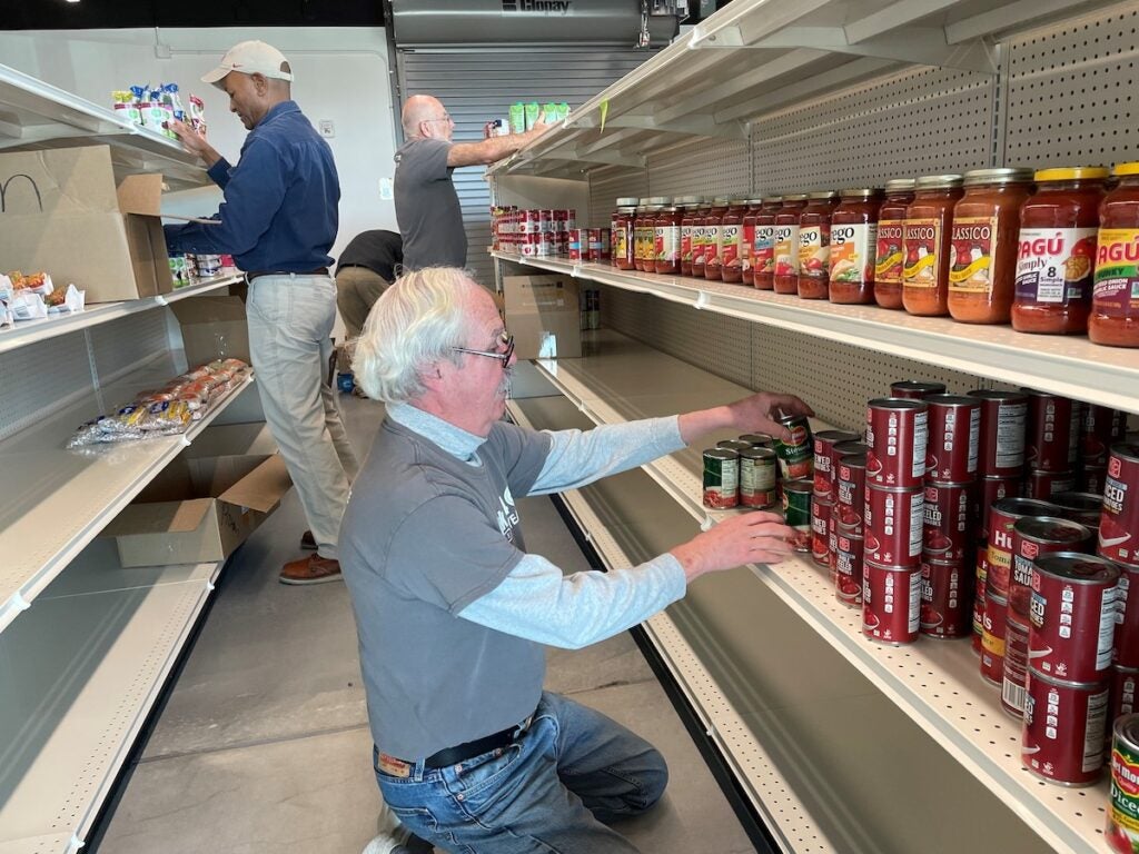 A person organizing food products on a shelf.
