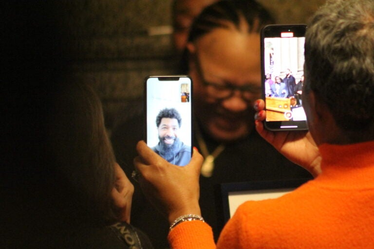 A person holds up phones showing Markieff Morris on Facetime