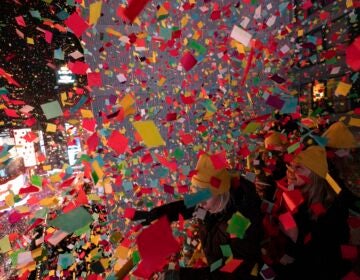 Times Square Alliance volunteers throw confetti as the clock strikes midnight