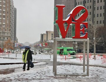 A person walking in Love Park in Philadelphia in the snow
