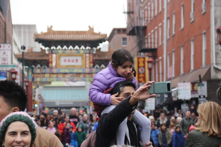 Attendees made sure to document their cherished memories of Sunday's Lunar New Year Parade. (Cory Sharber/WHYY)