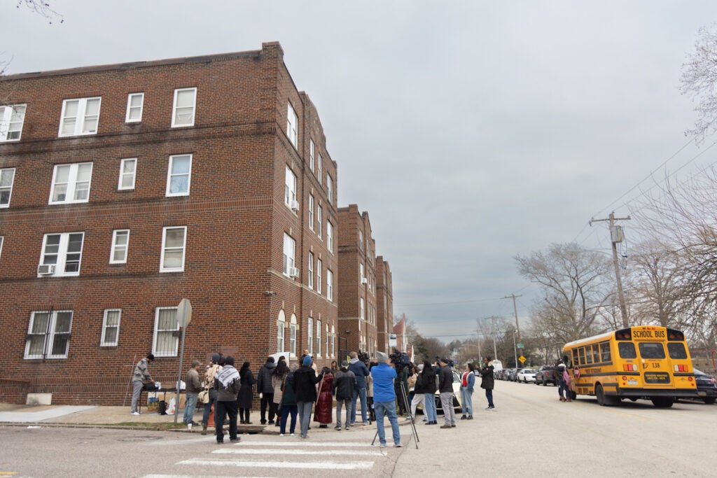 A group of people outside of Oak Lane Court apartments