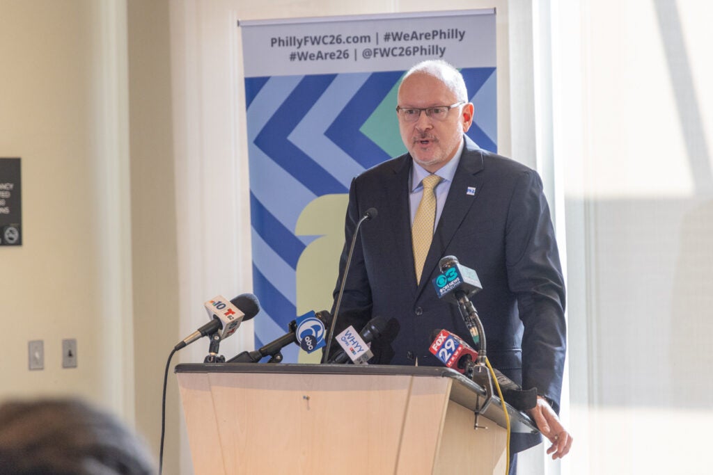 Gregg Caren speaking at a podium