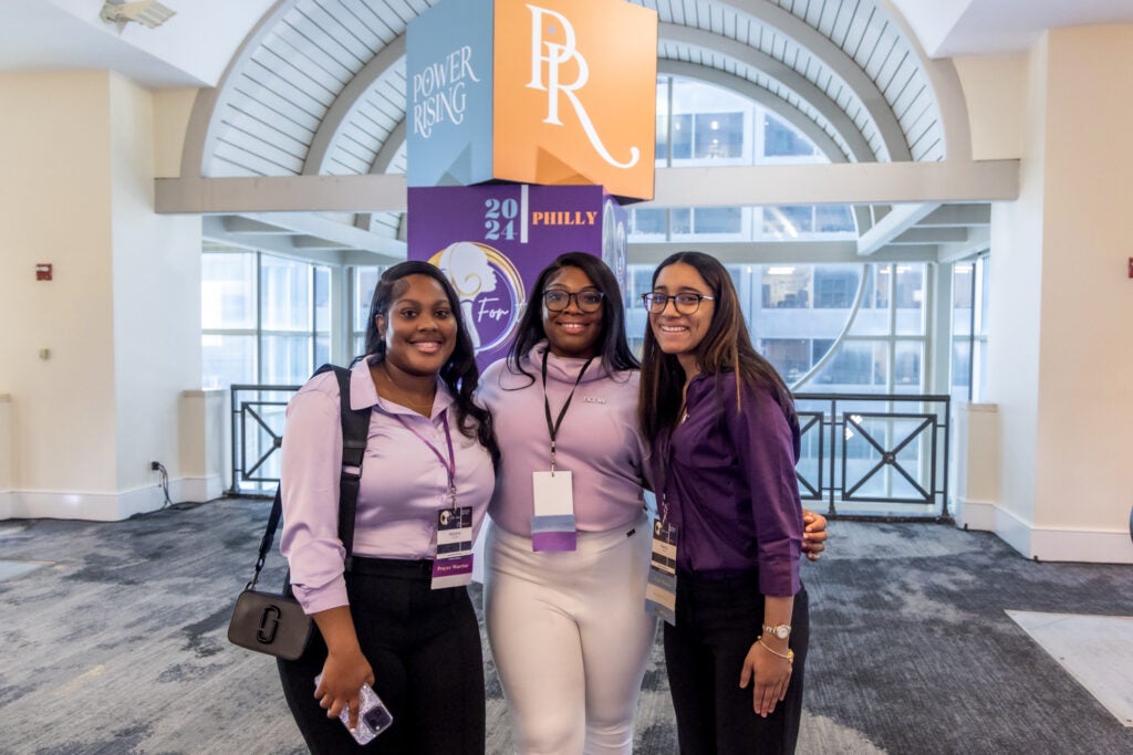 three women posing in the conference hall