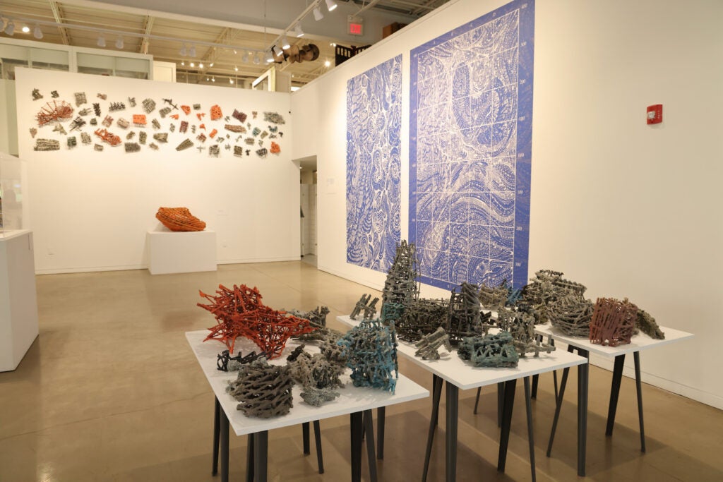 Small wooden sculptures displayed on a table at an exhibit