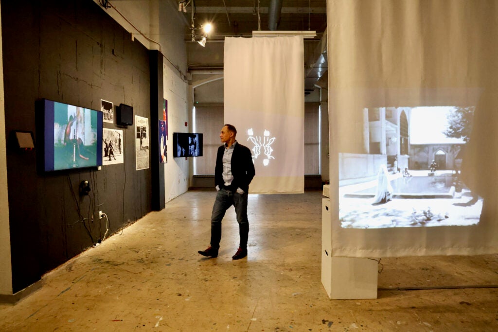 Vali Mahlouji stands in the middle of an exhibition space at at the Asian Arts Initiative.