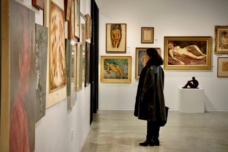 someone looking at paintings on the wall