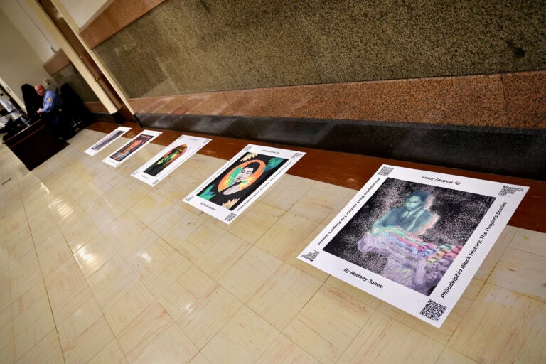Portraits of Black Philadelphians are displayed on the floor of City Hall