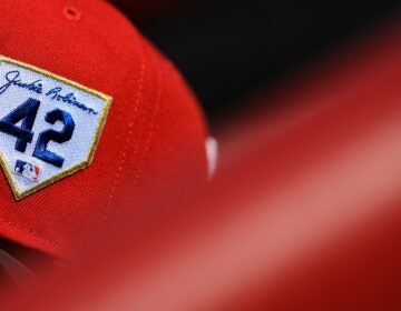 The Jackie Robinson patch is seen on a Philadelphia Phillies hat in the dugout during a baseball game against the Cincinnati Reds in Cincinnati, Saturday, April 15, 2023