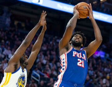 Philadelphia 76ers center Joel Embiid (21) shoots over Golden State Warriors forward Draymond Green (23) during the first half of an NBA basketball game, Tuesday, Jan. 30, 2024, in San Francisco.