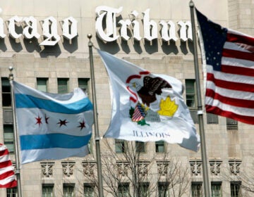 In this April 12, 2006, file photo, flags wave near the Chicago Tribune Tower in downtown Chicago. More than 200 reporters, photographers and other staffers with the Chicago Tribune and six other newsrooms around the nation began a 24-hour strike Thursday, Feb. 1, 2024 to protest years of “slow-walked” contract negotiations and to demand fair wages.