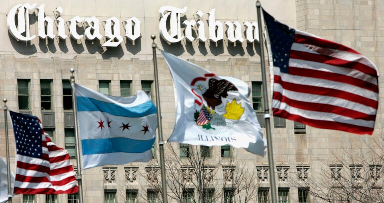 In this April 12, 2006, file photo, flags wave near the Chicago Tribune Tower in downtown Chicago. More than 200 reporters, photographers and other staffers with the Chicago Tribune and six other newsrooms around the nation began a 24-hour strike Thursday, Feb. 1, 2024 to protest years of “slow-walked” contract negotiations and to demand fair wages.