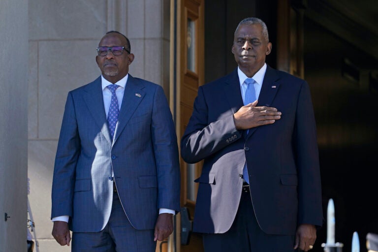 Defense Secretary Lloyd Austin (right) and Kenya's Defense Minister Aden Duale (left) listen during the National Anthem during a ceremony at the Pentagon in Washington, Wednesday, Feb. 7, 2024.