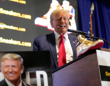 Trump speaks at a podium with gold sneakers in front of him