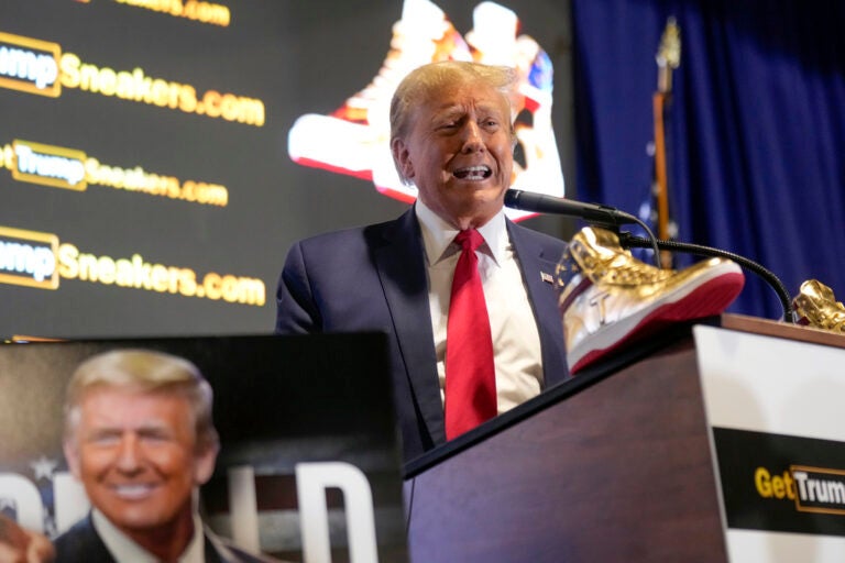 Trump speaks at a podium with gold sneakers in front of him