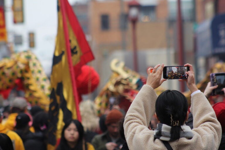 Attendees made sure to document their cherished memories of Sunday's Lunar New Year Parade. (Cory Sharber/WHYY)