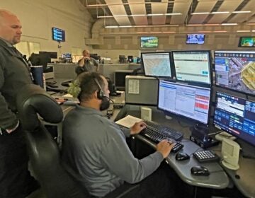 Supervisor Chris Williams observes dispatcher Onassis Burton taking a 911 call at the New Castle County emergency operations center south of Wilmington.