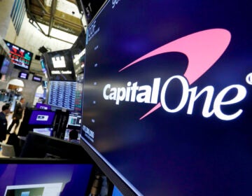 The logo for Capital One Financial is displayed above a trading post on the floor of the New York Stock Exchange.