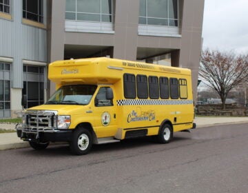 The Conshohocken Cab is parked outside a building