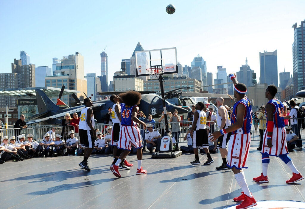 Harlem Globetrotters playing on a court with a view of the NYC skyline in the background