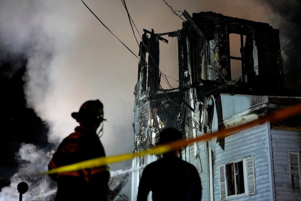 Firefighters work at the scene where two police officers were injured while responding to reported standoff in East Lansdowne, Pa., on Wednesday, Feb. 7, 2024.