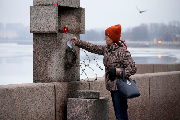 A woman places a piece of paper with words of grief for Alexei Navalny paying the last respect to him at the Memorial to Victims of Political Repression in St. Petersburg, Russia,