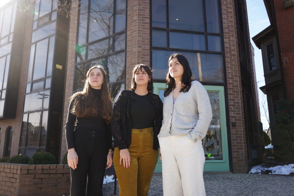 Evie Gentile, Sophie Cloarec and Christina Higashi-Howard pose for a photo together outside of a building