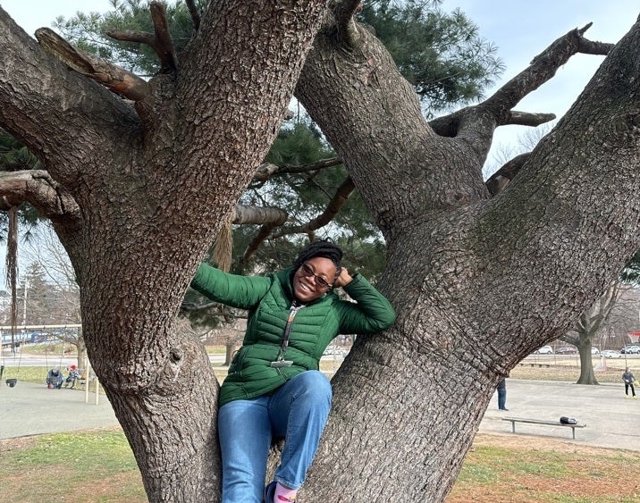 A person poses for a photo in a tree.