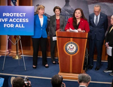 Sen. Tammy Duckworth, D-Ill., center, speaks about a bill to establish federal protections for IVF