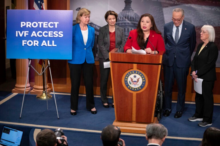 Sen. Tammy Duckworth, D-Ill., center, speaks about a bill to establish federal protections for IVF