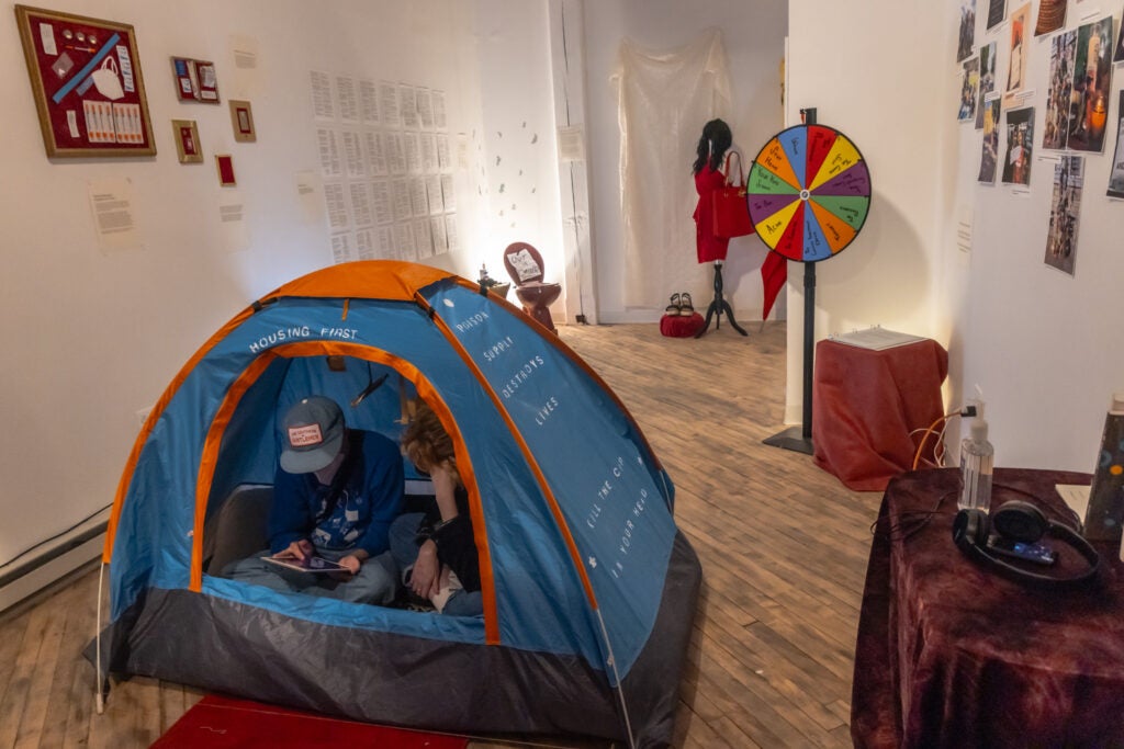 Two people inside of a tent in an art installation.