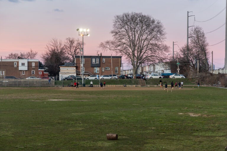 Kids play on a soccer field at twilight