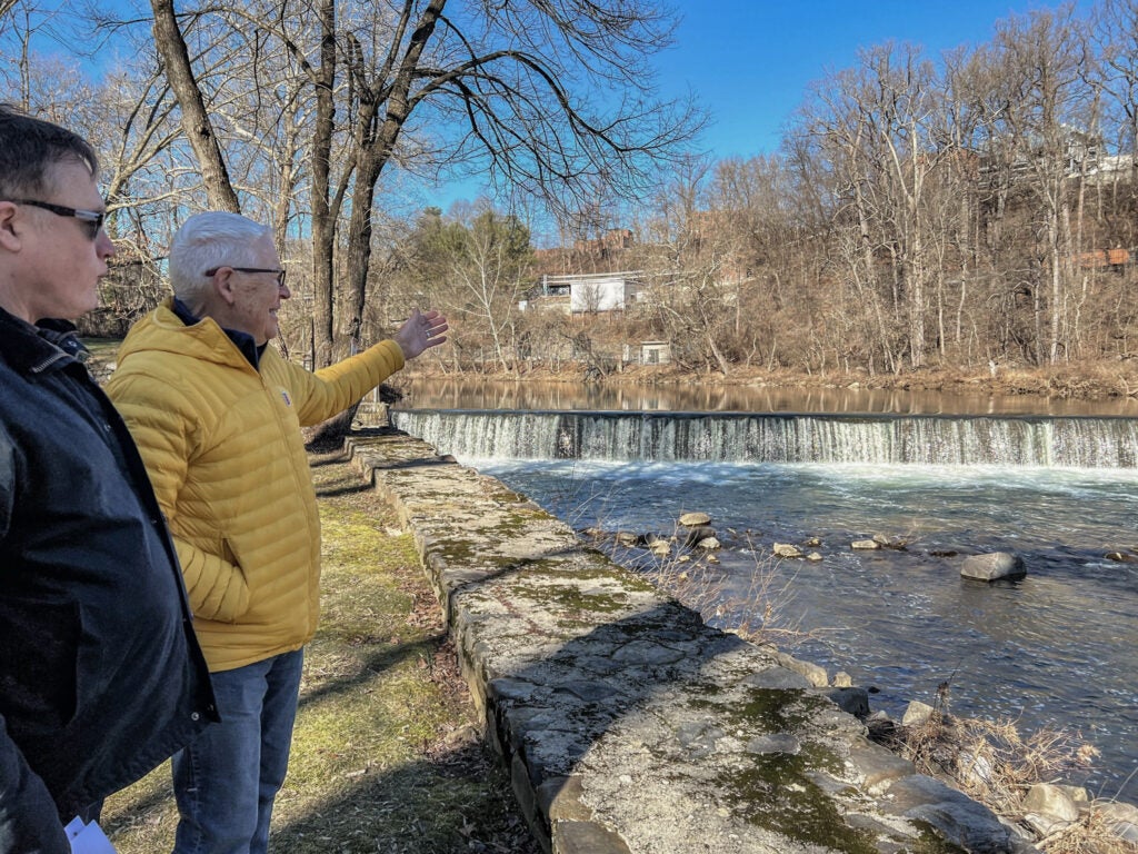 Brandywine Falls residents, Bob Hurka (right) and Jim Carrington (left) point towards a dam on the Brandywine River