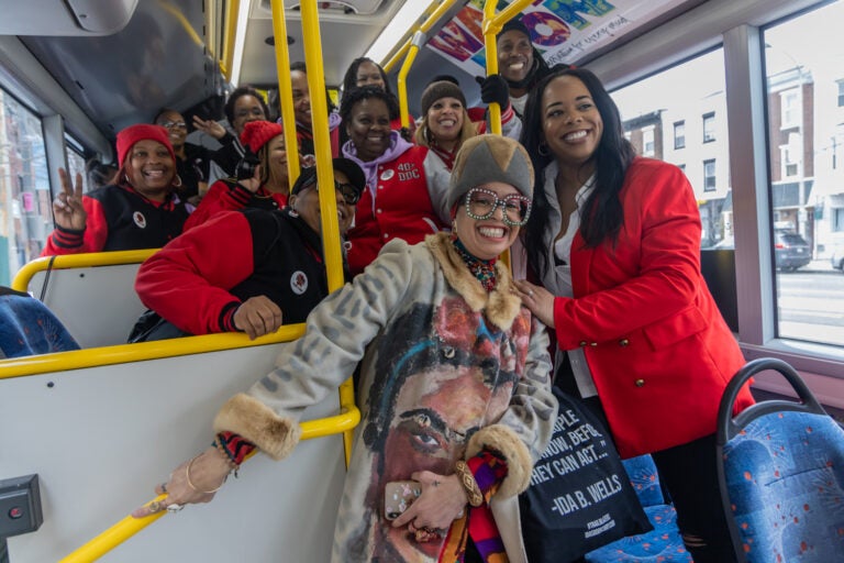 The Sisterhood Sit-In Trolley Tour’s guide, Starfire, poses with Philadelphia’s 40+ double dutch team on the bus on March 9, 2024.