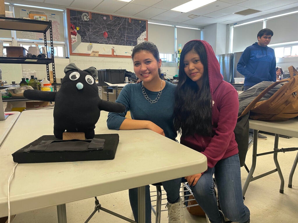 Daniela González and Mayda Jiguan pose next to "Wíx," an internet-connected prototype people can use to practice their language skills with.