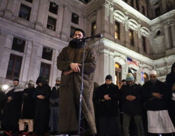 Ahmed Burhan, a well-known Quran reciter, leads prayers on Friday outside City Hall as devotees perform rakahs to show their humbleness and devotion. (Carmen Russell-Sluchansky/WHYY)