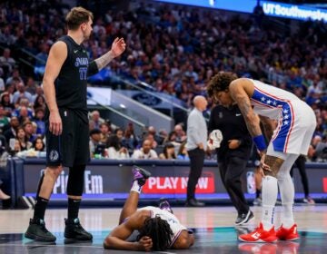 Philadelphia 76ers guard Tyrese Maxey (center) holds his head as Dallas Mavericks guard Luka Doncic (77) and 76ers guard Kelly Oubre Jr. (right) look on during the second half of an NBA basketball game Sunday, March 3, 2024, in Dallas.
