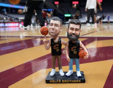 A bobblehead of Cleveland natives Travis and Jason Kelce stands on the Cleveland Cavaliers' court Sunday, March 3, 2024, in Cleveland. The team will give the bobbleheads to fans at an NBA basketball game against the Boston Celtics, Tuesday, March 5.
