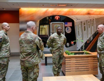 Members of the Armed Forces including the National Guard wait in the lobby of the New York City Mass Transit Authority Rail Control Center before the start of a news conference with Gov. Hochul, Wednesday, March 6, 2024, in New York.